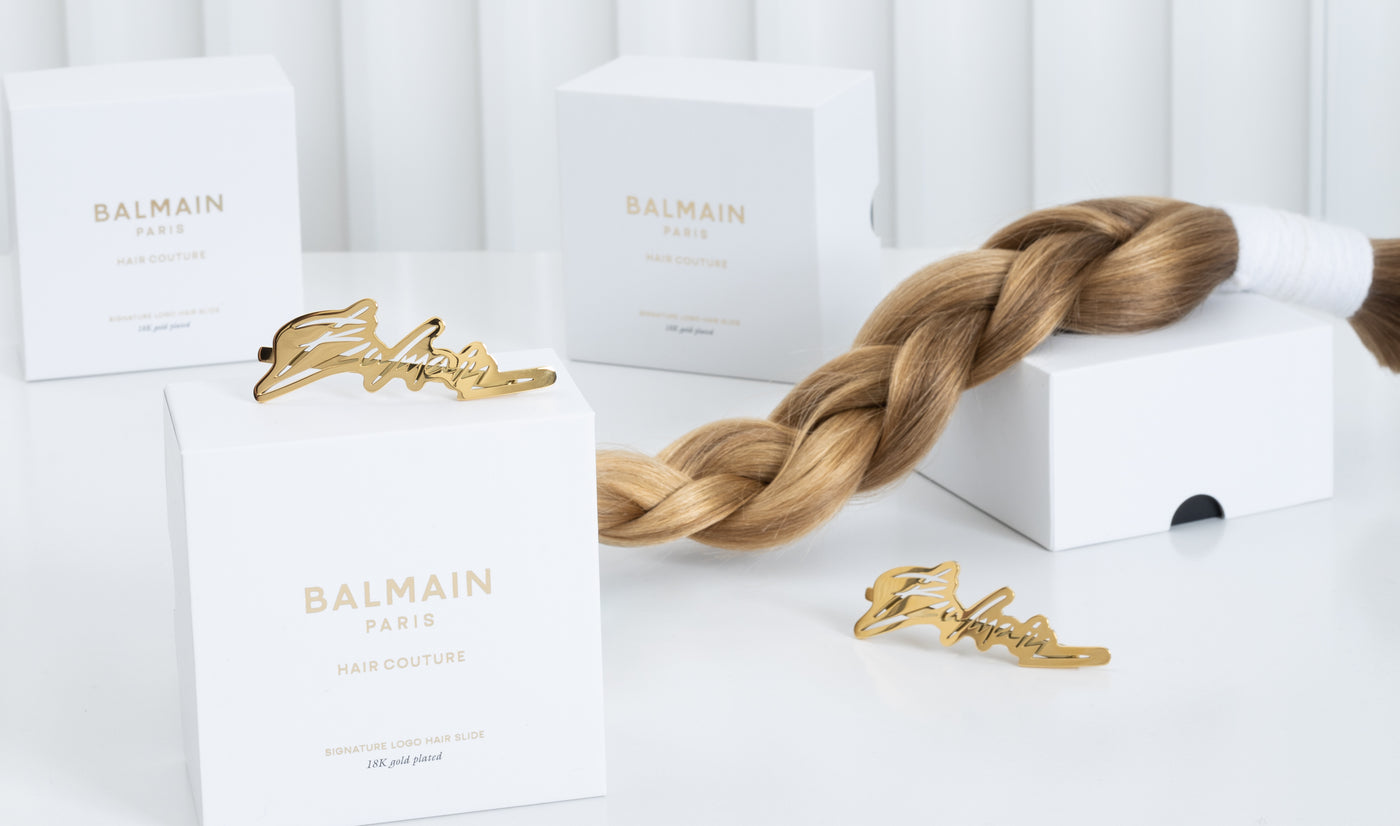 Dark blond braided human hair weft sitting on top of Balmain hair products. Shot in studio.